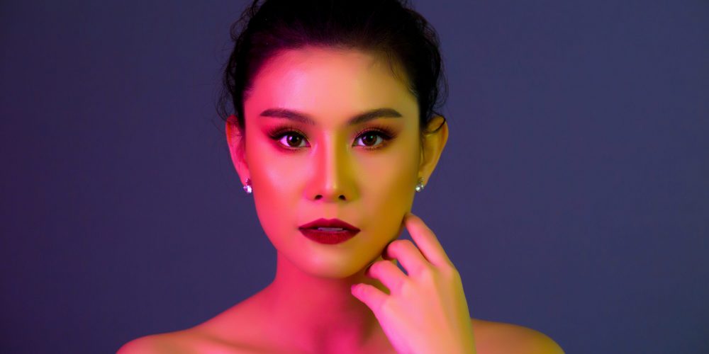 High Fashion model woman in colorful bright lights posing, portrait of beautiful sexy girl
