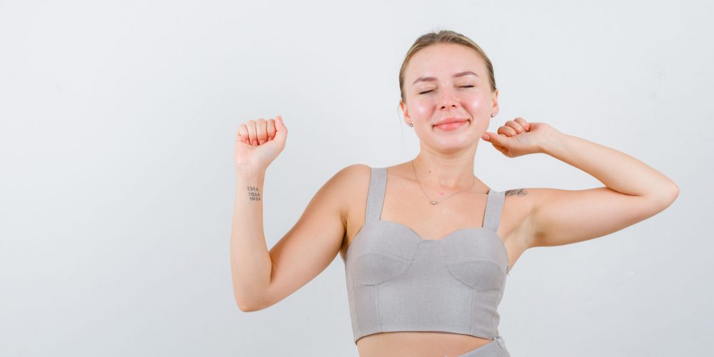 young girl stretching her hands above on white background